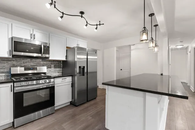 a kitchen with stainless steel appliances a stove a refrigerator and a microwave