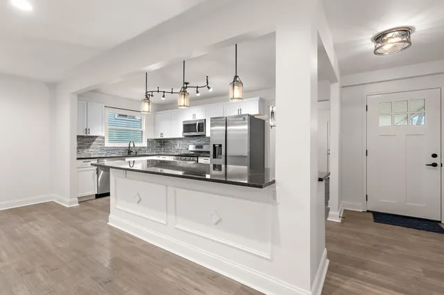 a kitchen with stainless steel appliances granite countertop a refrigerator and a stove top oven