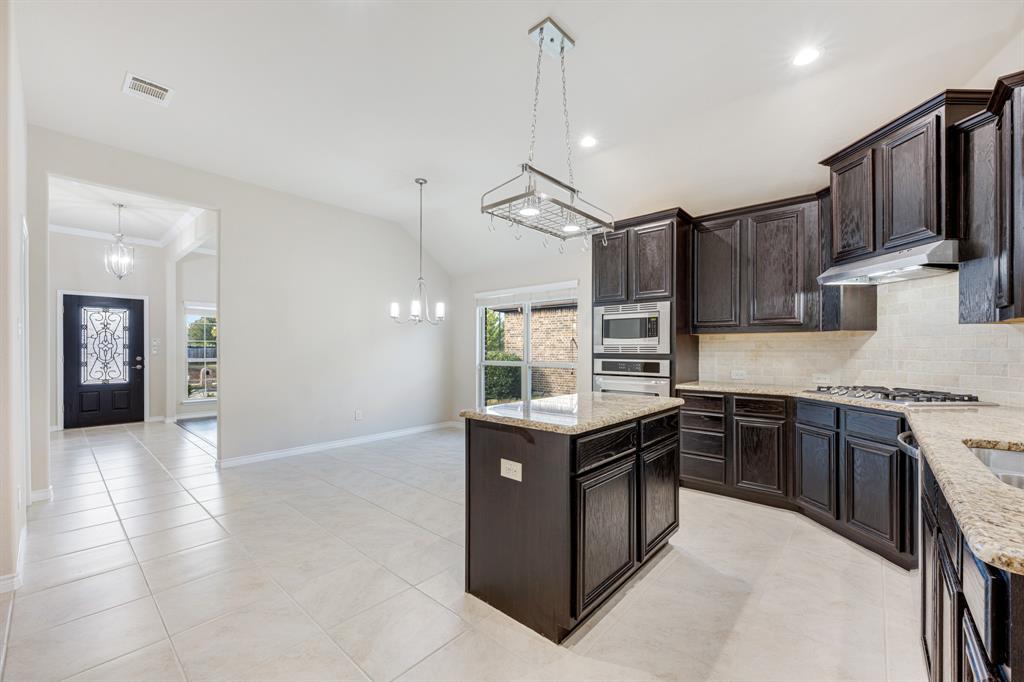 5022 Hidden Creek Road Garland, TX 75043 - Photo 11 of 36 a kitchen with stainless steel appliances granite countertop a stove top oven a sink and a refrigerator
