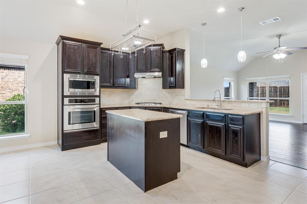 5022 Hidden Creek Road Garland, TX 75043 - Photo 12 of 36 a kitchen with stainless steel appliances granite countertop a stove a sink and a refrigerator