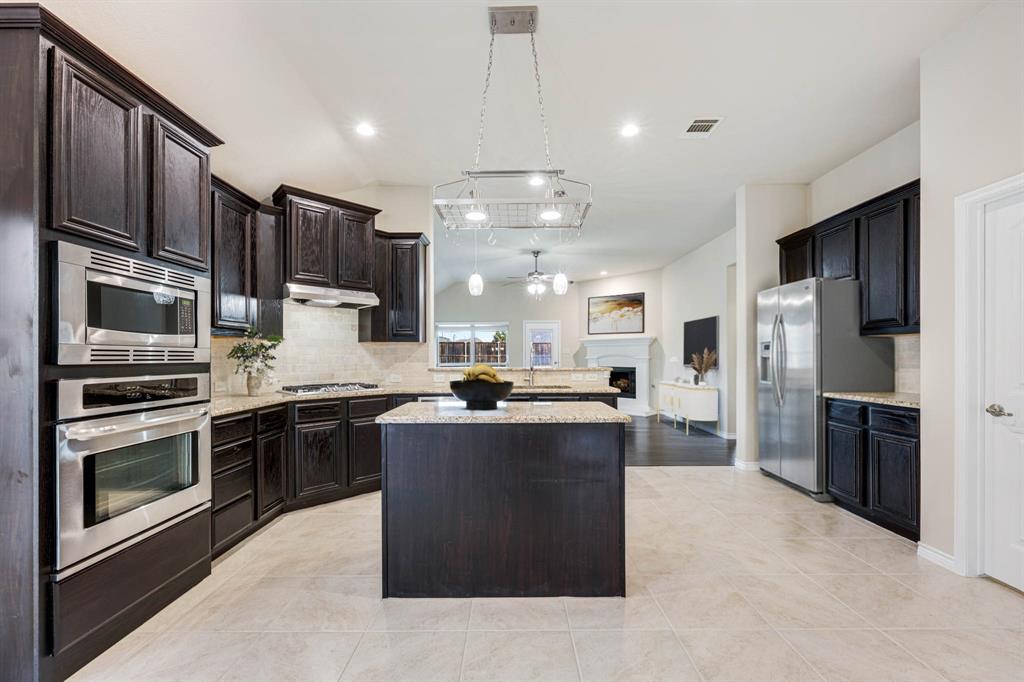 5022 Hidden Creek Road Garland, TX 75043 - Photo 10 of 36 a kitchen with stainless steel appliances granite countertop a stove refrigerator and microwave