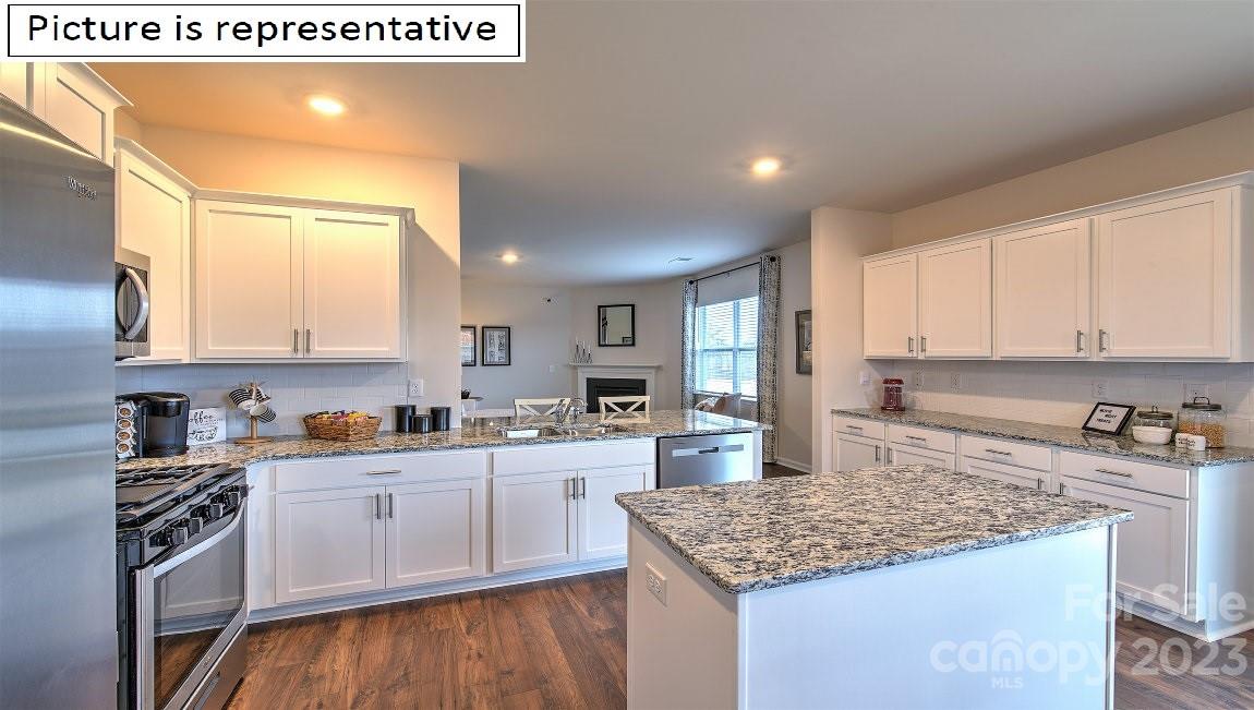 142 Flame Azalea Court Locust, NC 28097 - Photo 17 of 40 a kitchen with stainless steel appliances granite countertop a sink stove and refrigerator
