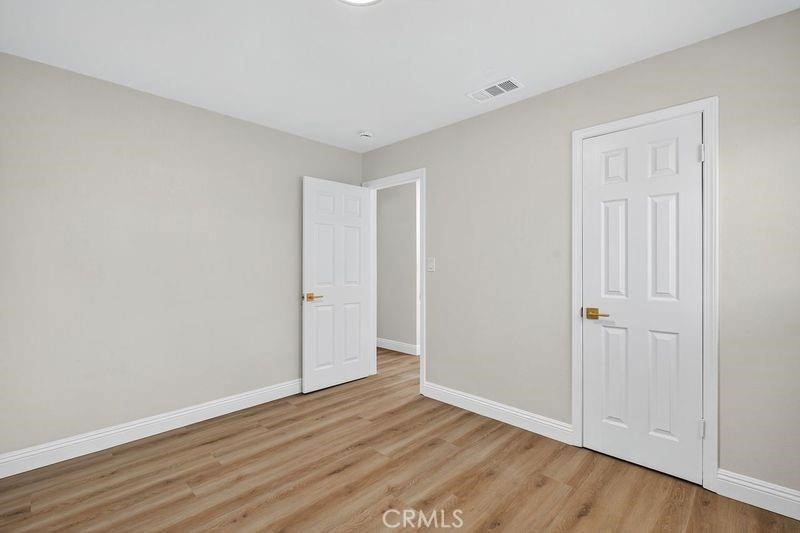 18222 10th Street Bloomington, CA 92316 - Photo 16 of 22 a view of an empty room with wooden floor