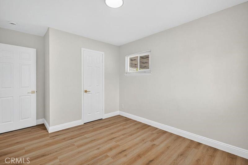 18222 10th Street Bloomington, CA 92316 - Photo 17 of 22 a view of an empty room with wooden floor and a window