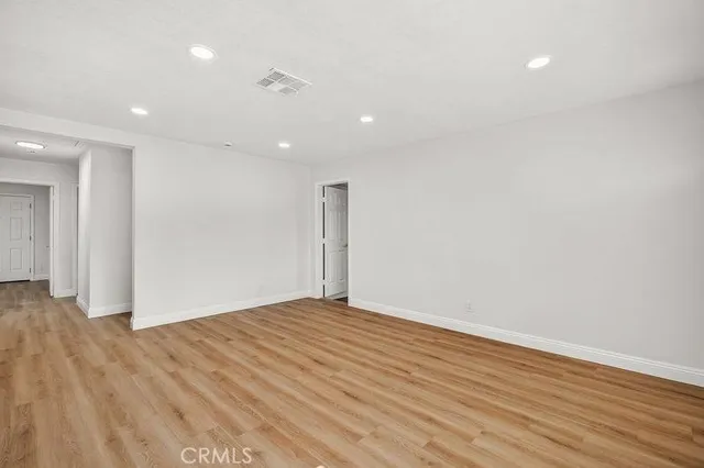 a view of an empty room with wooden floor
