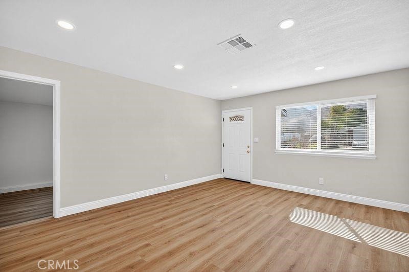 18222 10th Street Bloomington, CA 92316 - Photo 4 of 22 a view of an empty room with wooden floor and a window