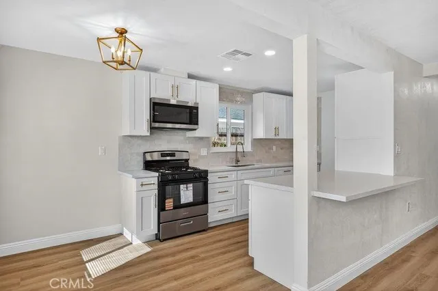 a kitchen with granite countertop a refrigerator and a stove top oven