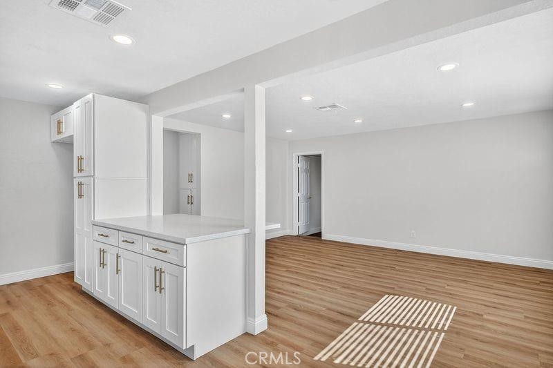 18222 10th Street Bloomington, CA 92316 - Photo 10 of 22 a kitchen with stainless steel appliances a white cabinets and wooden floor