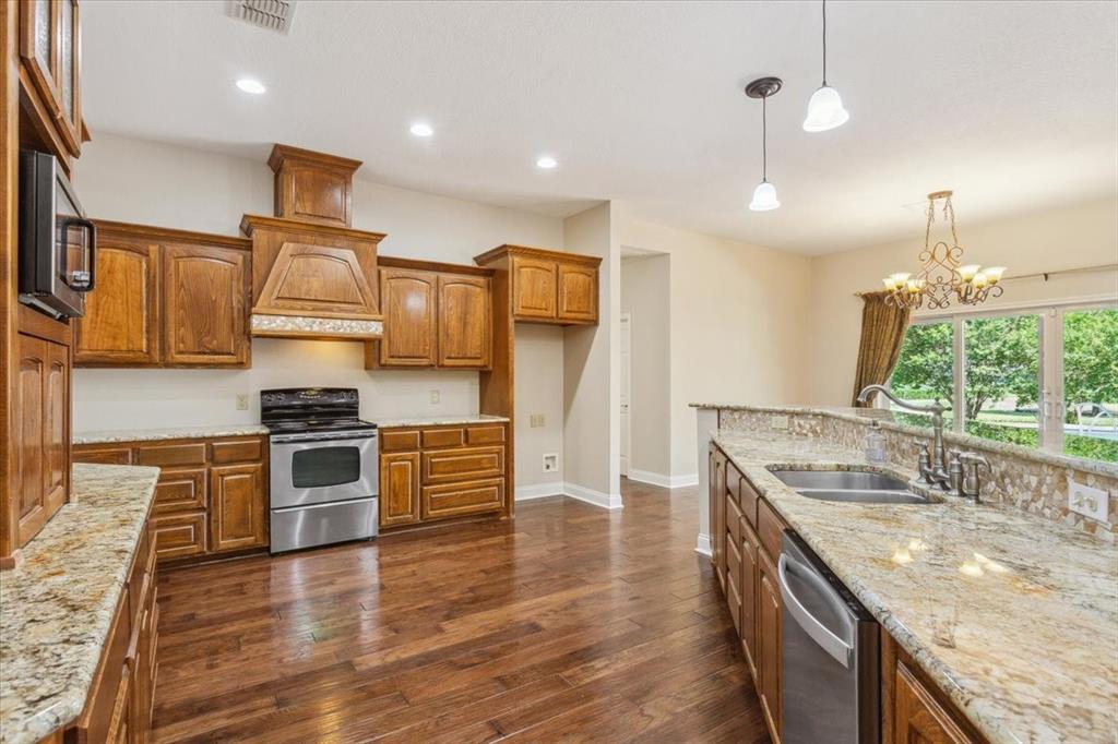 3439 Willow Branch Road McGregor, TX 76657 - Photo 11 of 40 a kitchen with stainless steel appliances granite countertop a sink a stove and a wooden floors