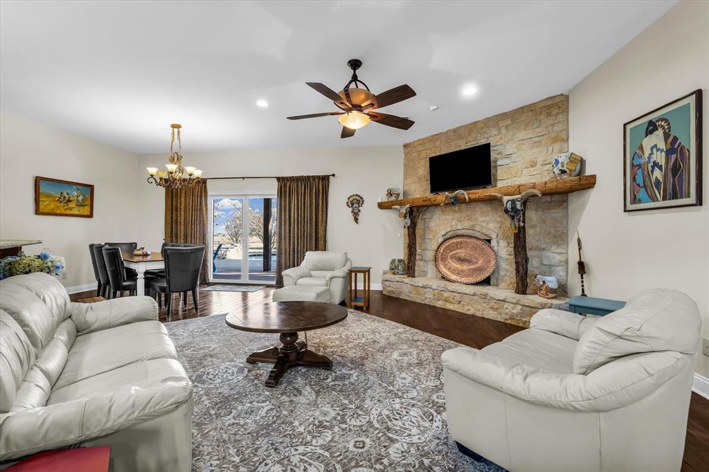 3439 Willow Branch Road McGregor, TX 76657 - Photo 7 of 40 a living room with furniture a flat screen tv and a chandelier