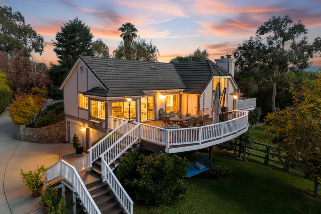 a view of backyard with deck and seating space