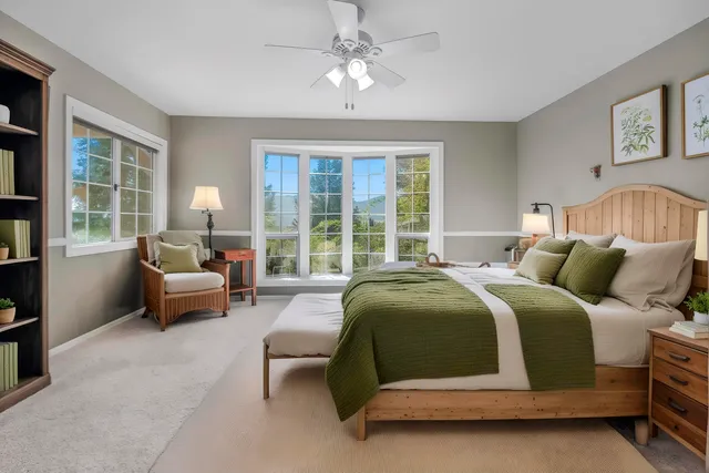 a bed sitting in a spacious bedroom next to a window