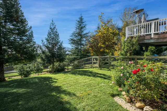 a view of a chair and table in backyard of the house