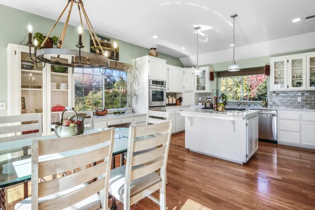 a kitchen that has a lot of cabinets in it and wooden floors