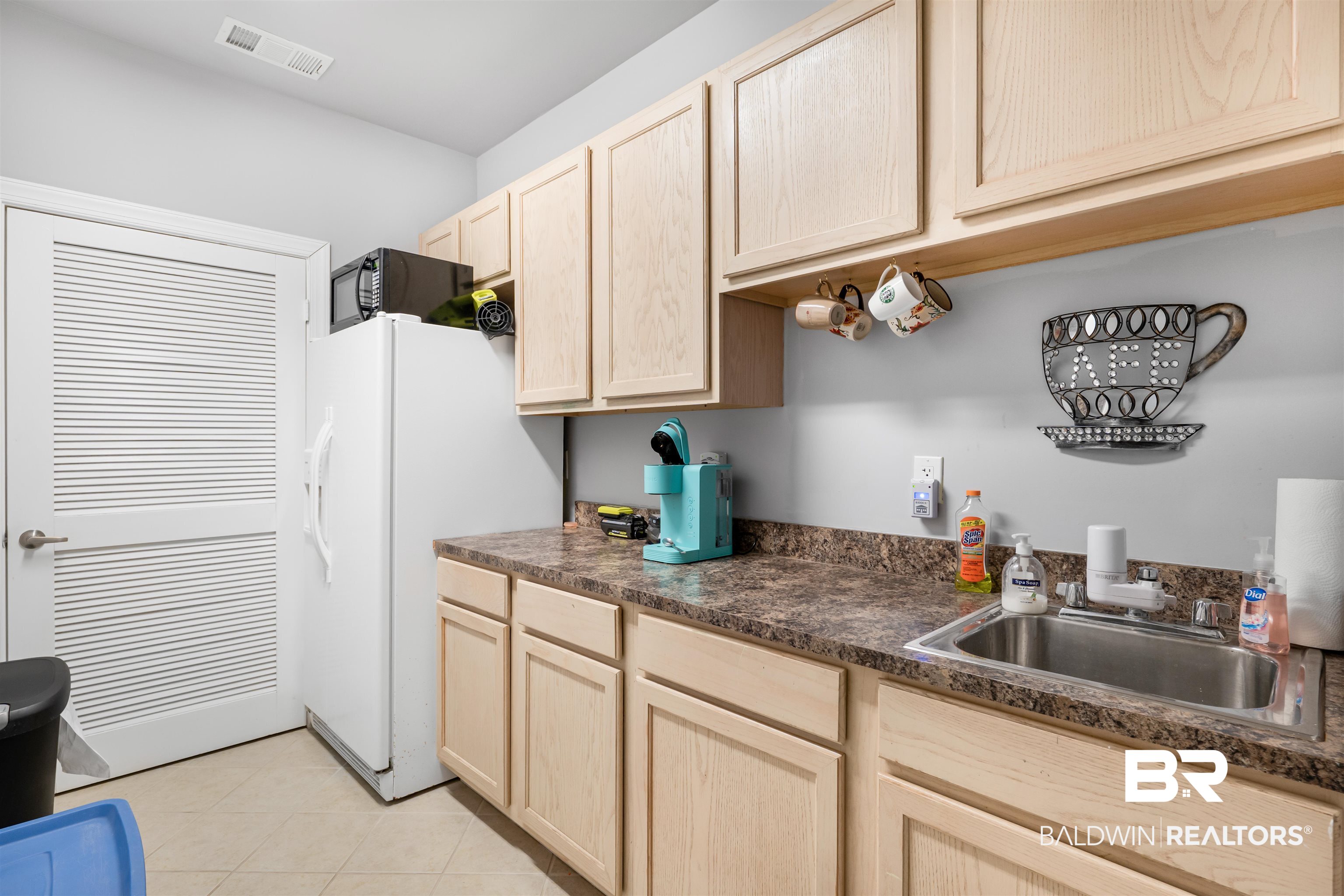1517 Regency Road, Unit 68 Gulf Shores, AL 36542 - Photo 39 of 43 Kitchen featuring light brown cabinets, white fridge with ice dispenser, sink, and light tile patterned floors