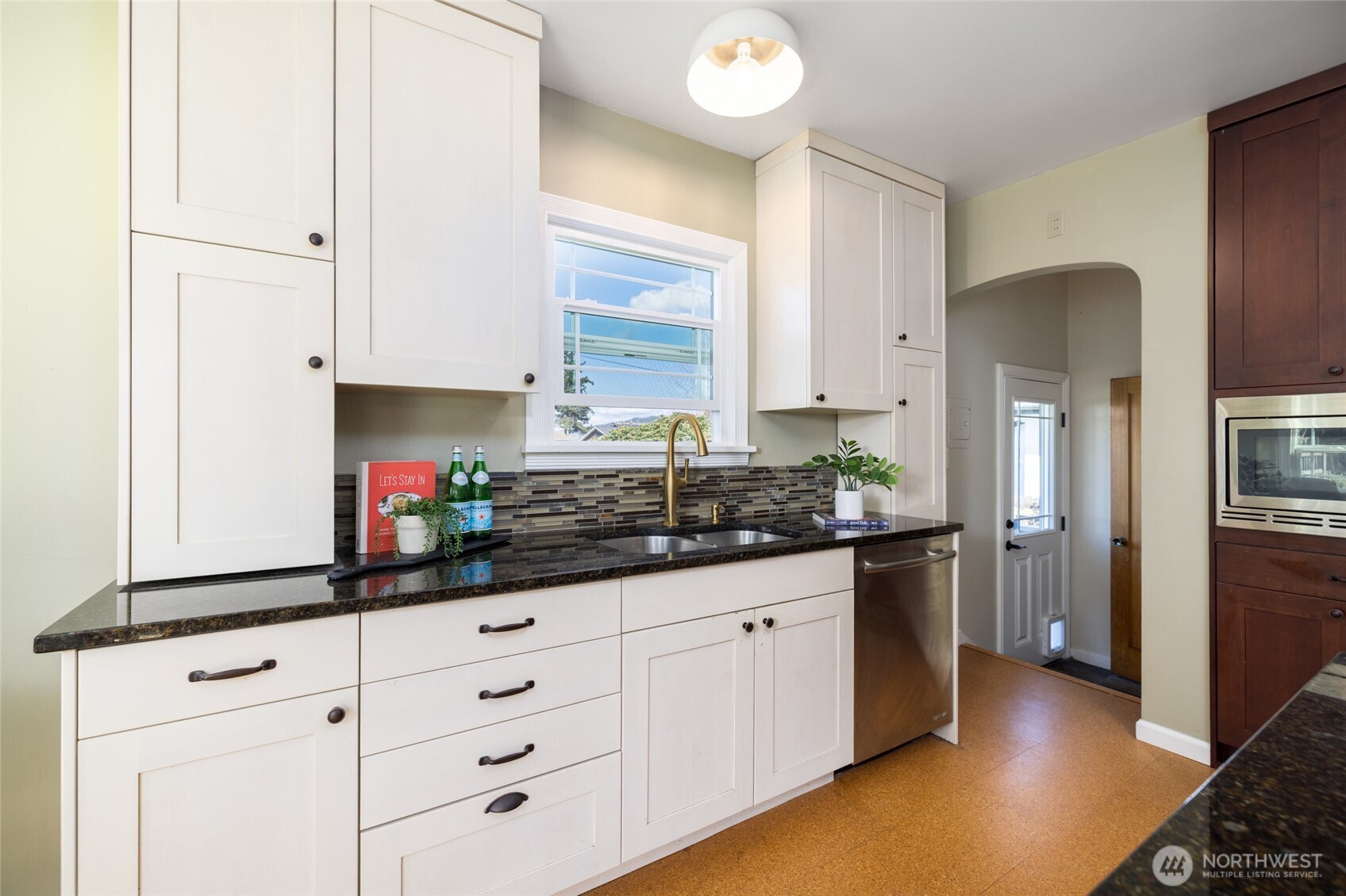 819 K Avenue Anacortes, WA 98221 - Photo 13 of 40 a kitchen with granite countertop white cabinets and white appliances
