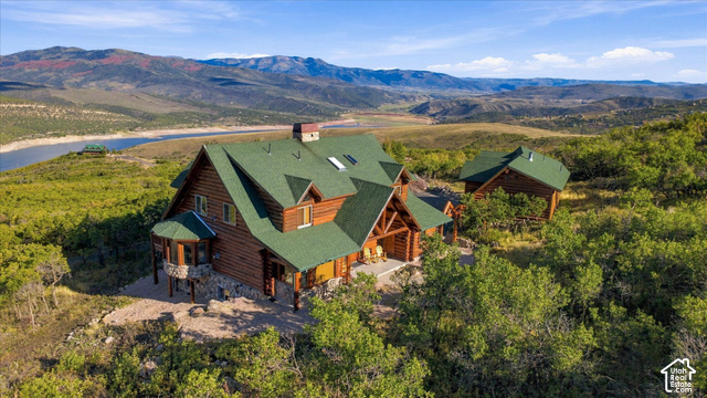 1701 Oak Road Coalville, UT 84017 - Photo 7 of 71 Log home construction with a green roof, multiple dormer windows, stone foundation accents, and a covered porch