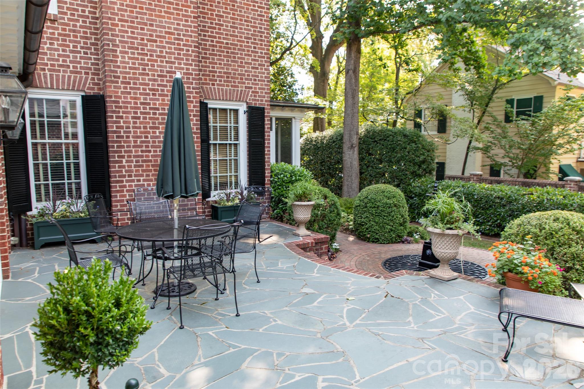 213 Union Street North Concord, NC 28025 - Photo 32 of 43 a view of a patio with plants and table and chairs under an umbrella