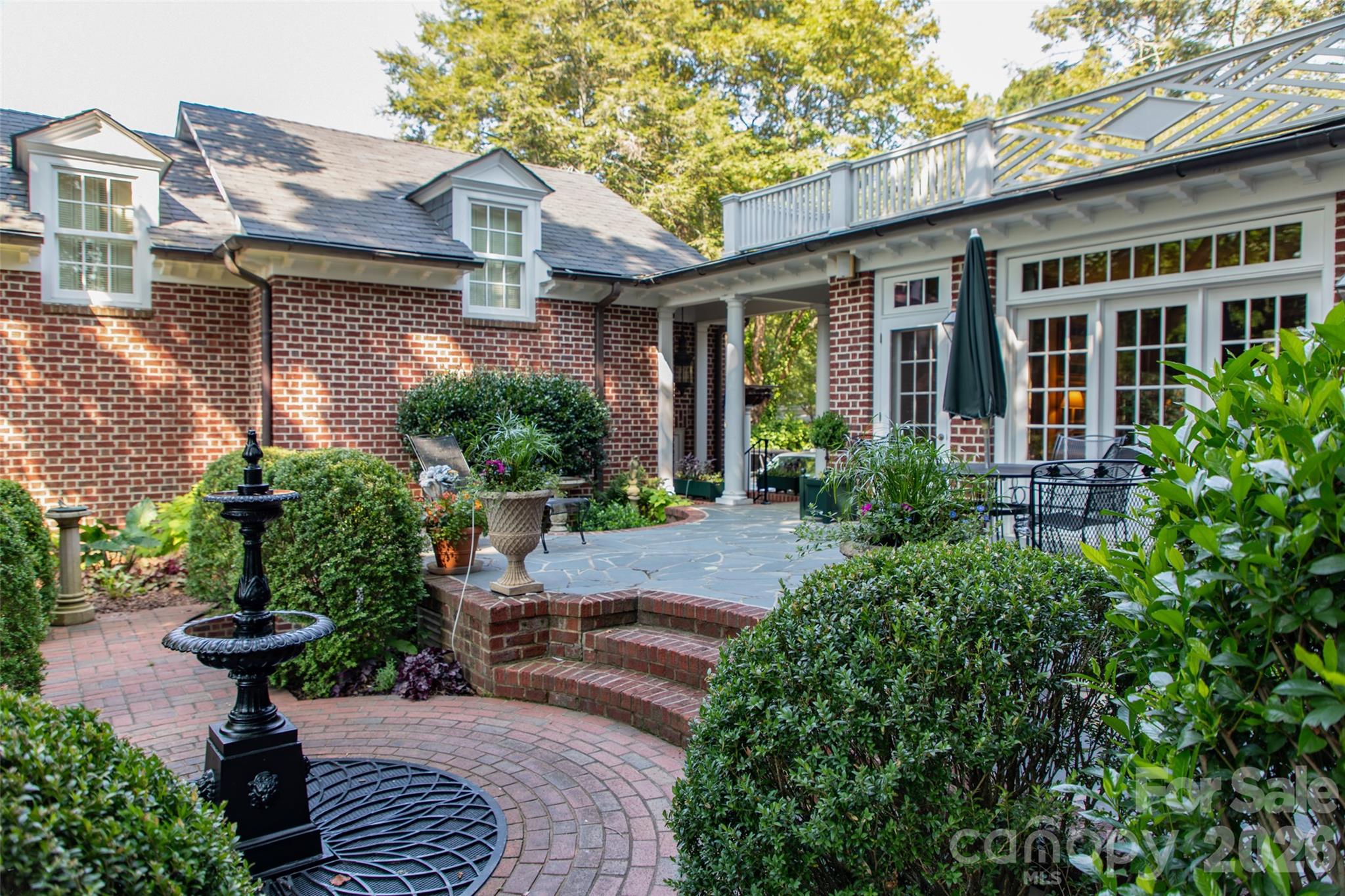 213 Union Street North Concord, NC 28025 - Photo 35 of 43 a view of brick house with potted plants and a table and chairs
