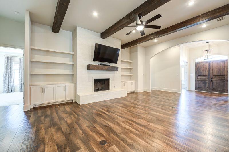 11107 Miami Avenue Lubbock, TX 79423 - Photo 11 of 82 a view of a livingroom with a flat screen tv wooden floor and a ceiling fan