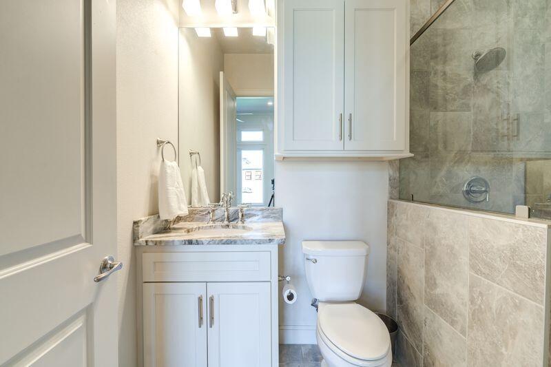 11107 Miami Avenue Lubbock, TX 79423 - Photo 51 of 82 a bathroom with a granite countertop toilet sink and mirror