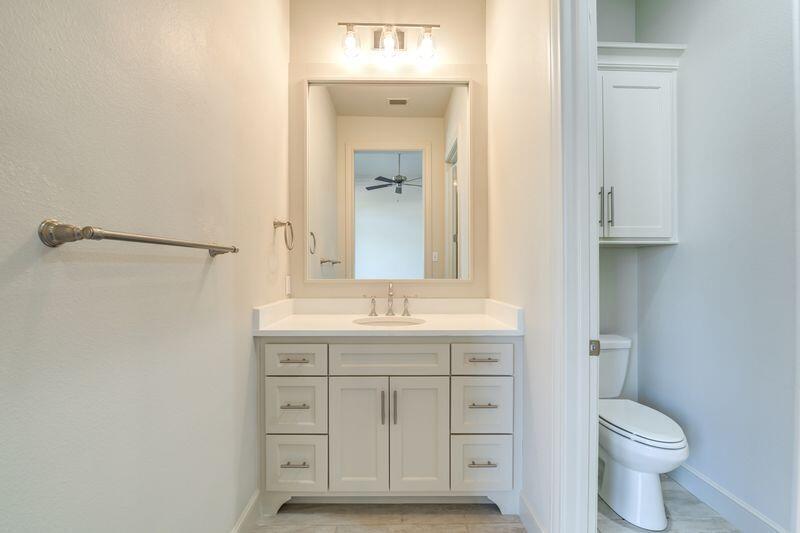 11107 Miami Avenue Lubbock, TX 79423 - Photo 56 of 82 a bathroom with a granite countertop sink toilet and mirror