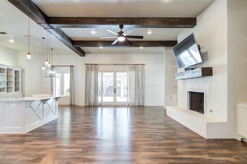 11107 Miami Avenue Lubbock, TX 79423 - Photo 8 of 82 a view of an empty room with wooden floor and a fireplace