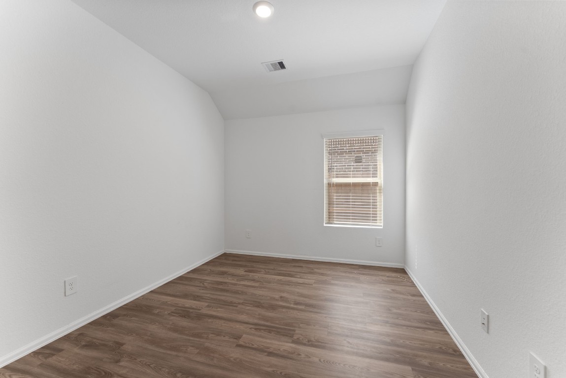 2850 Paradise Ridge Way Conroe, TX 77301 - Photo 16 of 22 a view of an empty room with wooden floor and a window