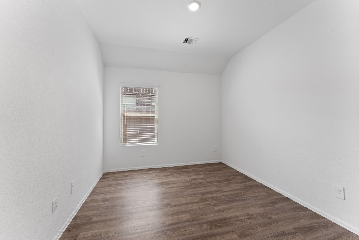 2850 Paradise Ridge Way Conroe, TX 77301 - Photo 18 of 22 a view of an empty room with wooden floor and a window