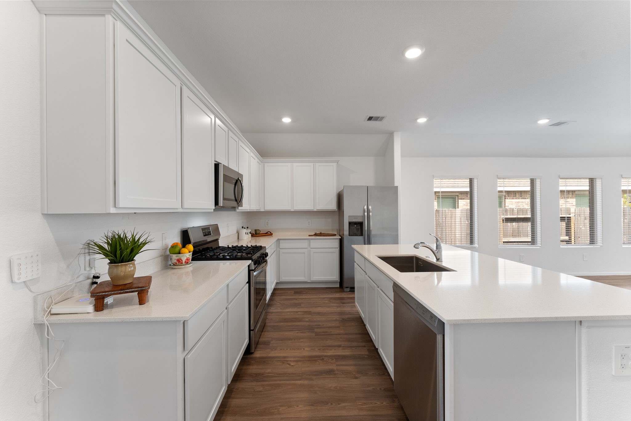 2850 Paradise Ridge Way Conroe, TX 77301 - Photo 5 of 21 This kitchen features white cabinetry and stainless steel appliances, including a gas stove and dishwasher. It has a spacious island with a sink, ample counter space, bar seating.
