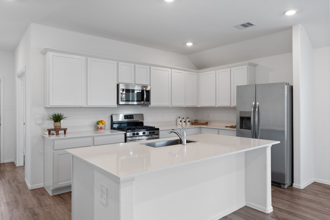 2850 Paradise Ridge Way Conroe, TX 77301 - Photo 6 of 22 a kitchen with stainless steel appliances a refrigerator sink and white cabinets