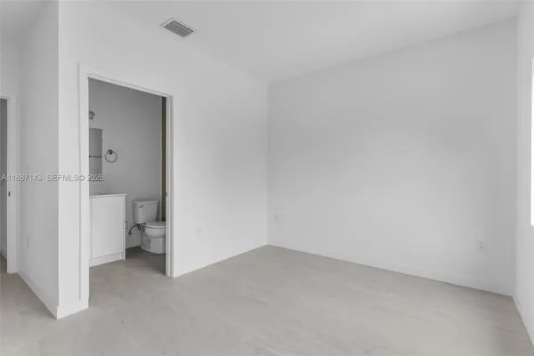 a bathroom with a granite countertop toilet a sink and mirror