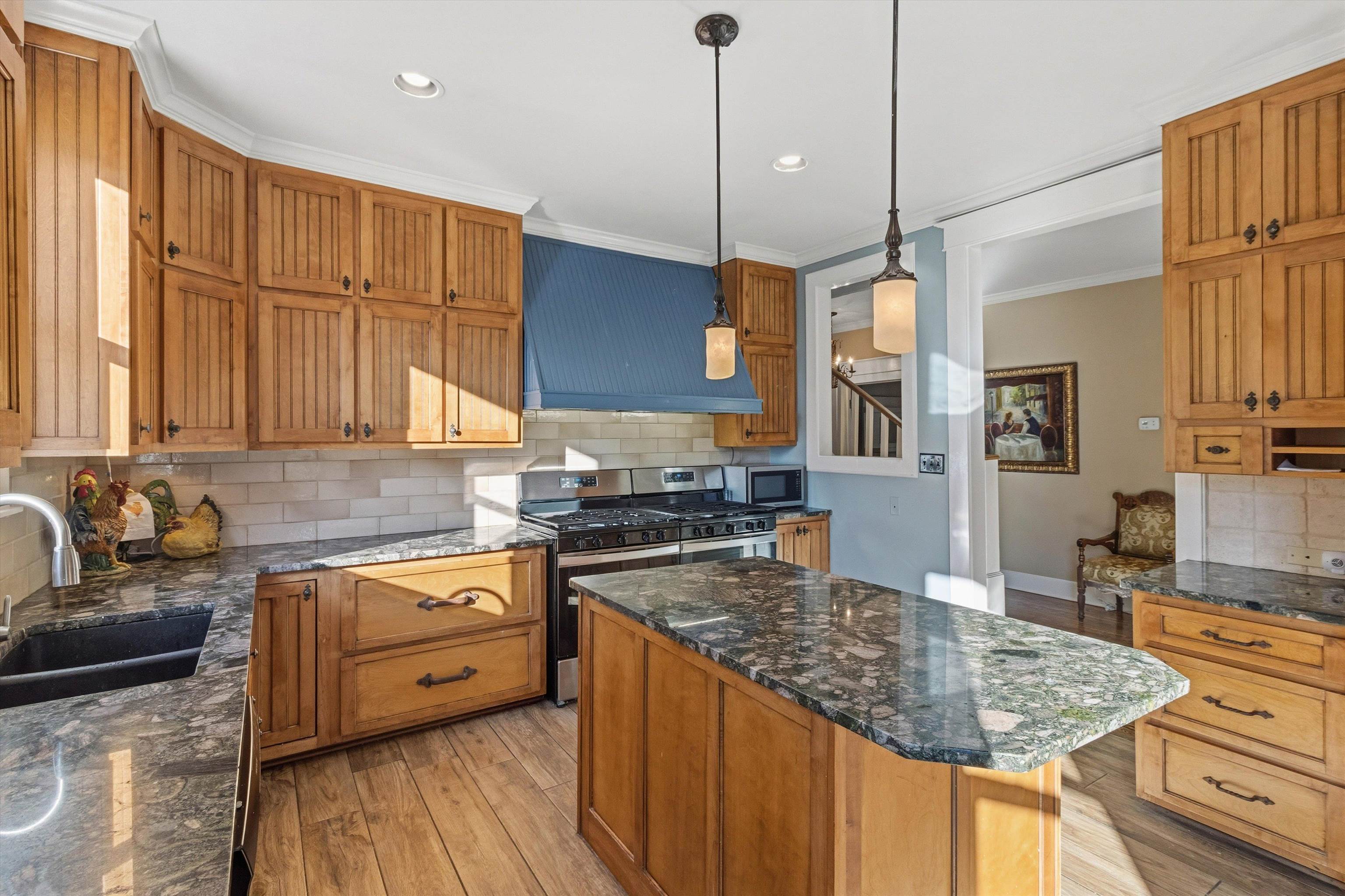 30 Front Street Rossville, TN 38066 - Photo 20 of 39 Kitchen with brown cabinets, tasteful backsplash, dark stone countertops, appliances with stainless steel finishes, and hanging light fixtures
