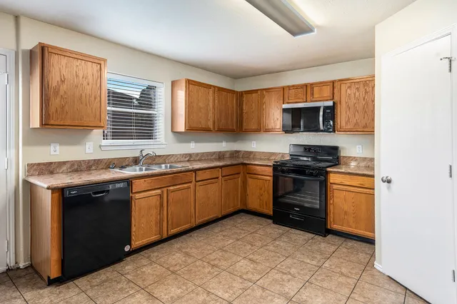a kitchen with stainless steel appliances granite countertop a stove sink and microwave