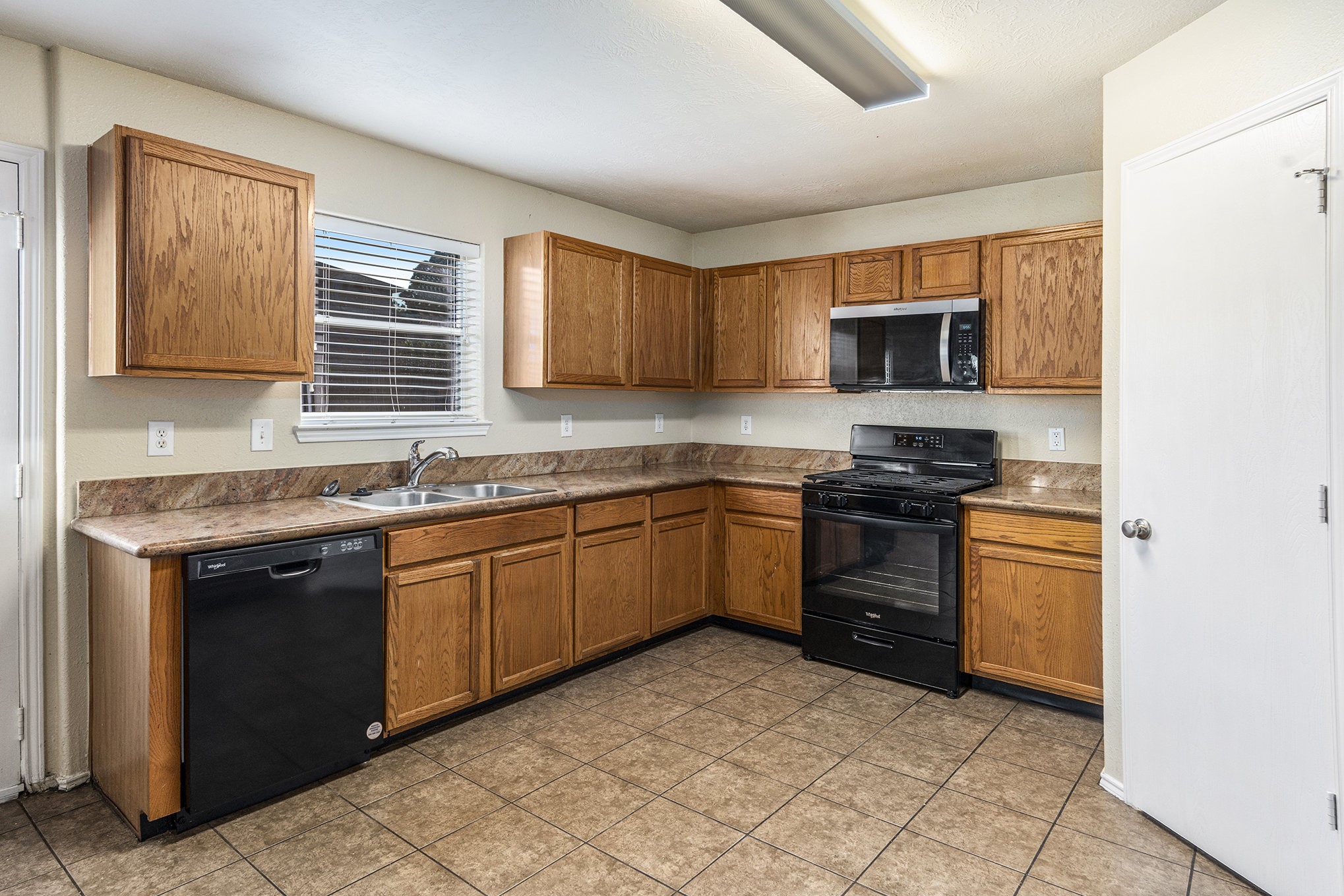 18227 Thicket Grove Road Houston, TX 77084 - Photo 11 of 28 a kitchen with stainless steel appliances granite countertop a stove sink and microwave