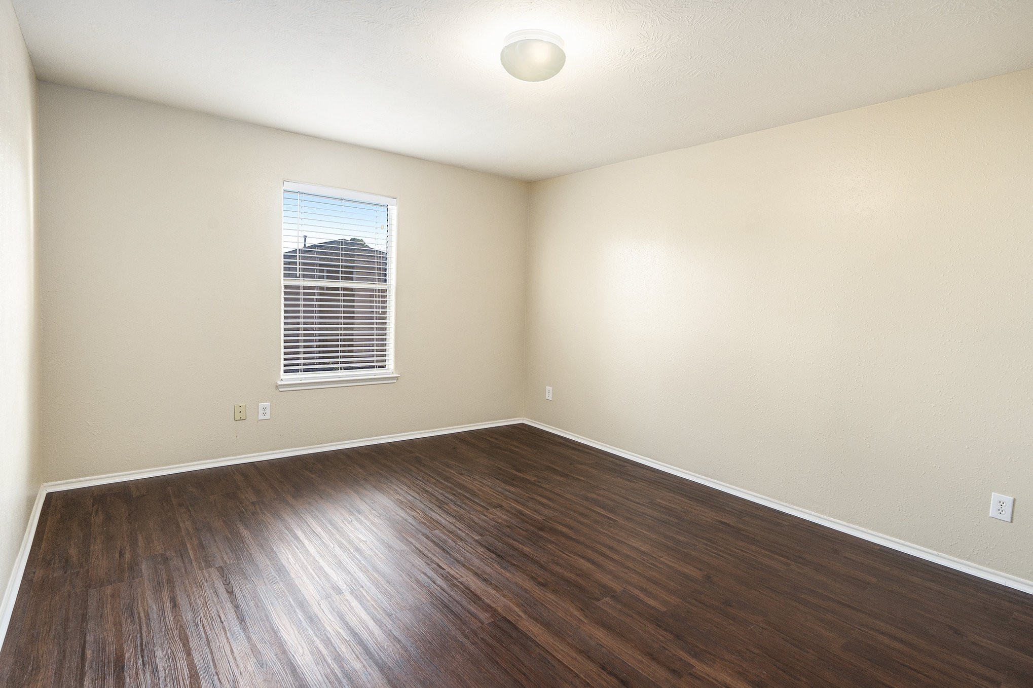 18227 Thicket Grove Road Houston, TX 77084 - Photo 22 of 28 an empty room with wooden floor and windows