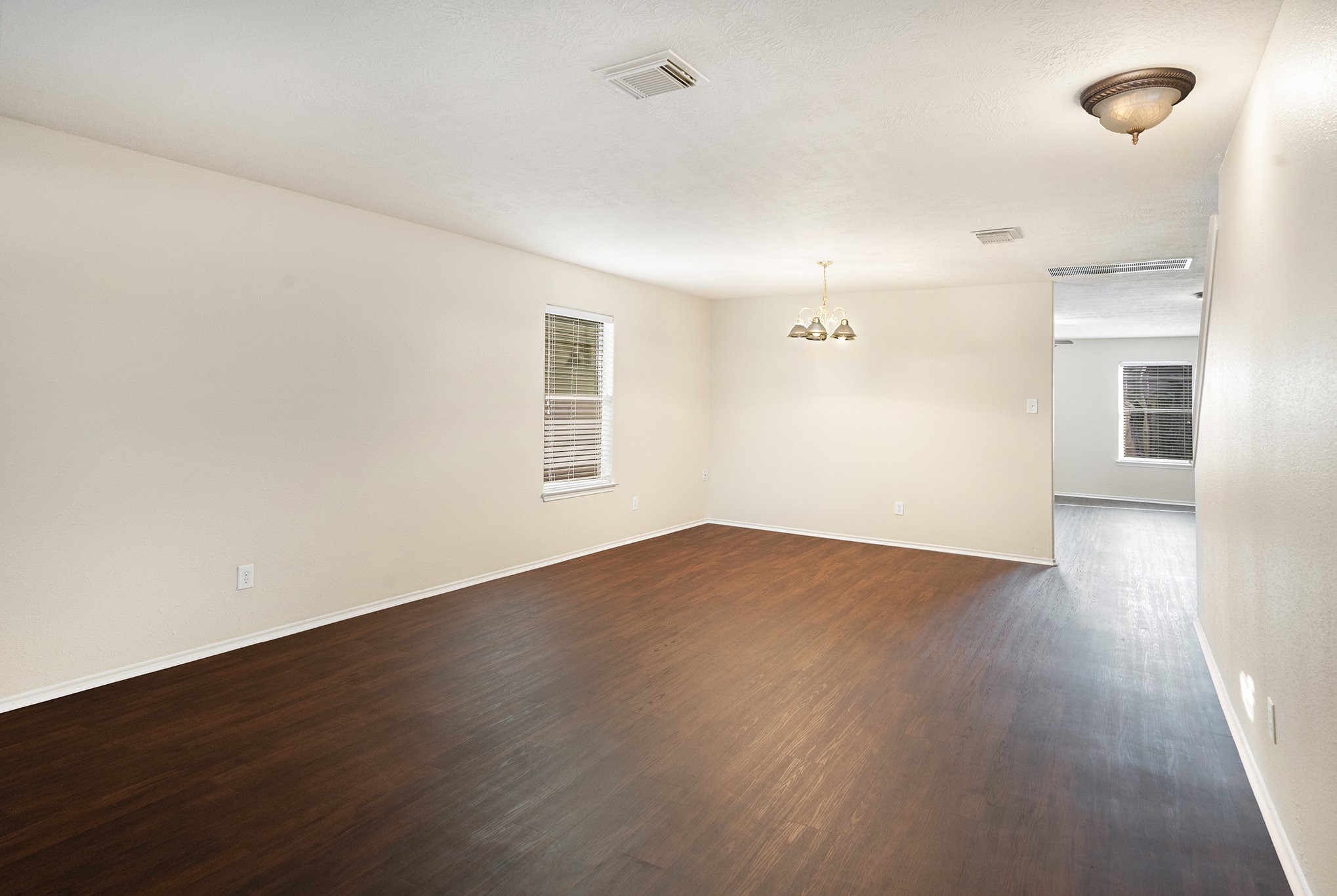 18227 Thicket Grove Road Houston, TX 77084 - Photo 7 of 28 an empty room with wooden floor and windows