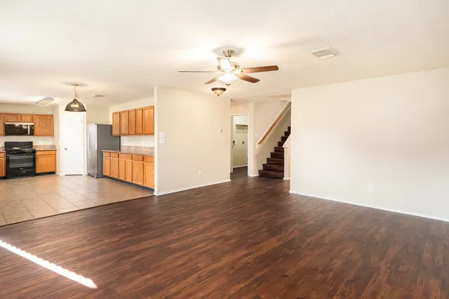 a view of a livingroom with wooden floor and a ceiling fan