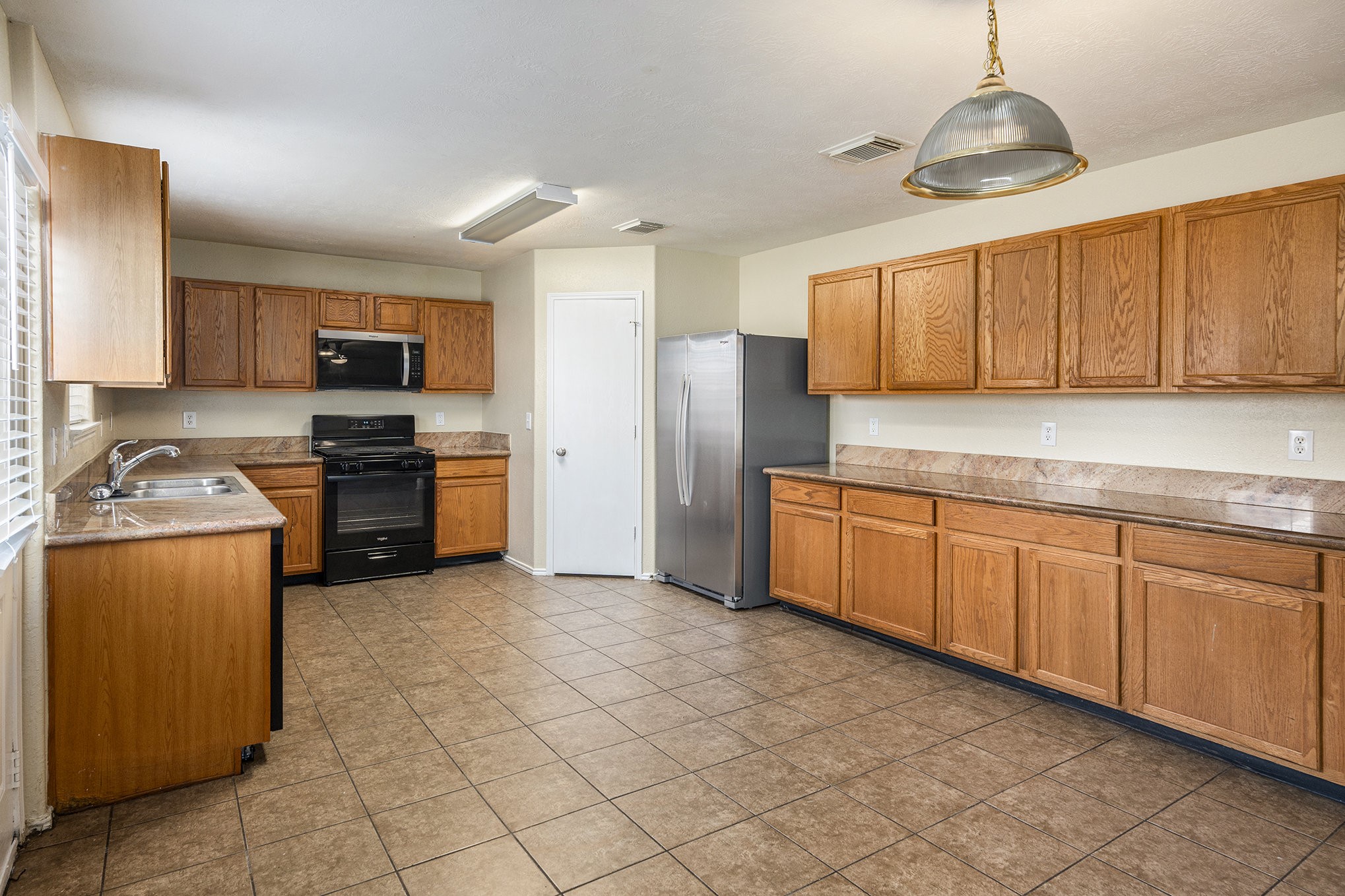 18227 Thicket Grove Road Houston, TX 77084 - Photo 10 of 28 a kitchen with stainless steel appliances granite countertop a stove sink and cabinets