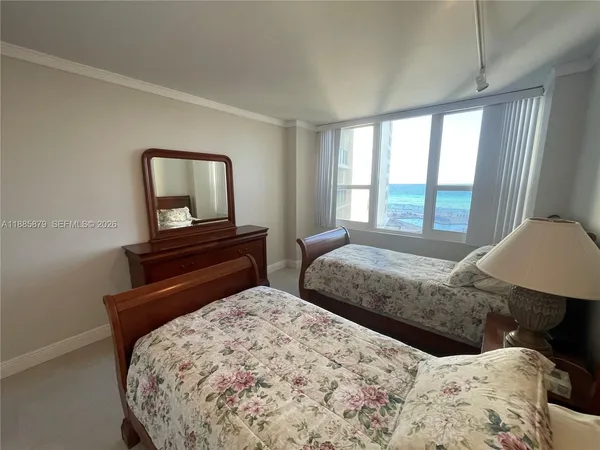 a bedroom with a bed and a dresser with mirror