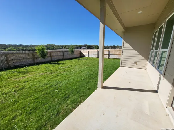 a view of a backyard with wooden fence
