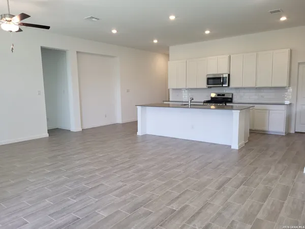 a view of kitchen with granite countertop stainless steel appliances refrigerator sink and cabinets