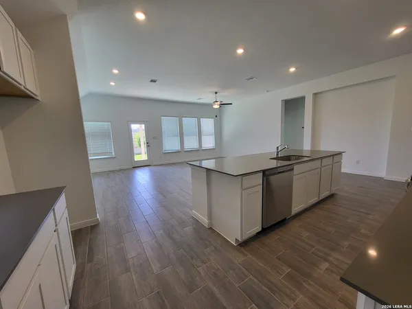 a kitchen with stainless steel appliances granite countertop a sink and wooden floors