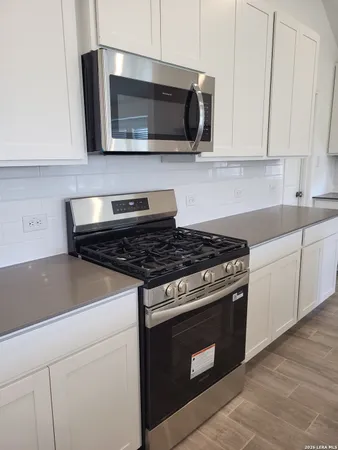 a kitchen with stainless steel appliances granite countertop a stove and a microwave