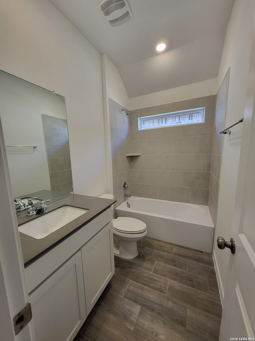 1233 Fox Wing Way New Braunfels, TX 78132 - Photo 9 of 19 a bathroom with a granite countertop sink toilet a large mirror a bathtub and shower