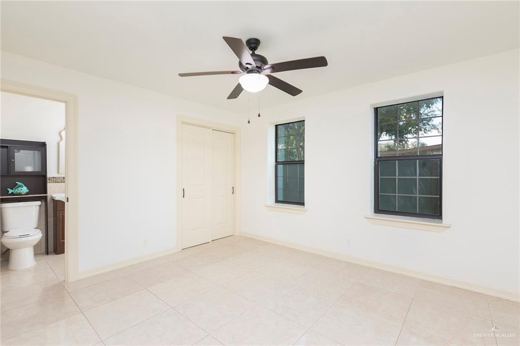 1312 North 5th Street McAllen, TX 78501 - Photo 20 of 25 The fifth bedroom and bathroom is spacious and filled with natural light, complete with a full bath. It offers a comfortable and versatile space perfect for family or guests.