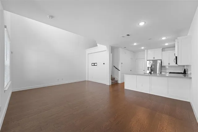 a large kitchen with stainless steel appliances a large counter top a stove and a refrigerator