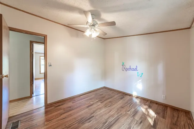 a view of empty room with wooden floor
