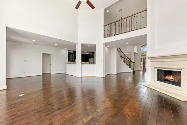 an empty room with wooden floor and a fireplace