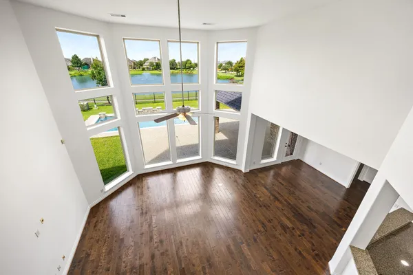 a view of an empty room with window wooden floor and front door